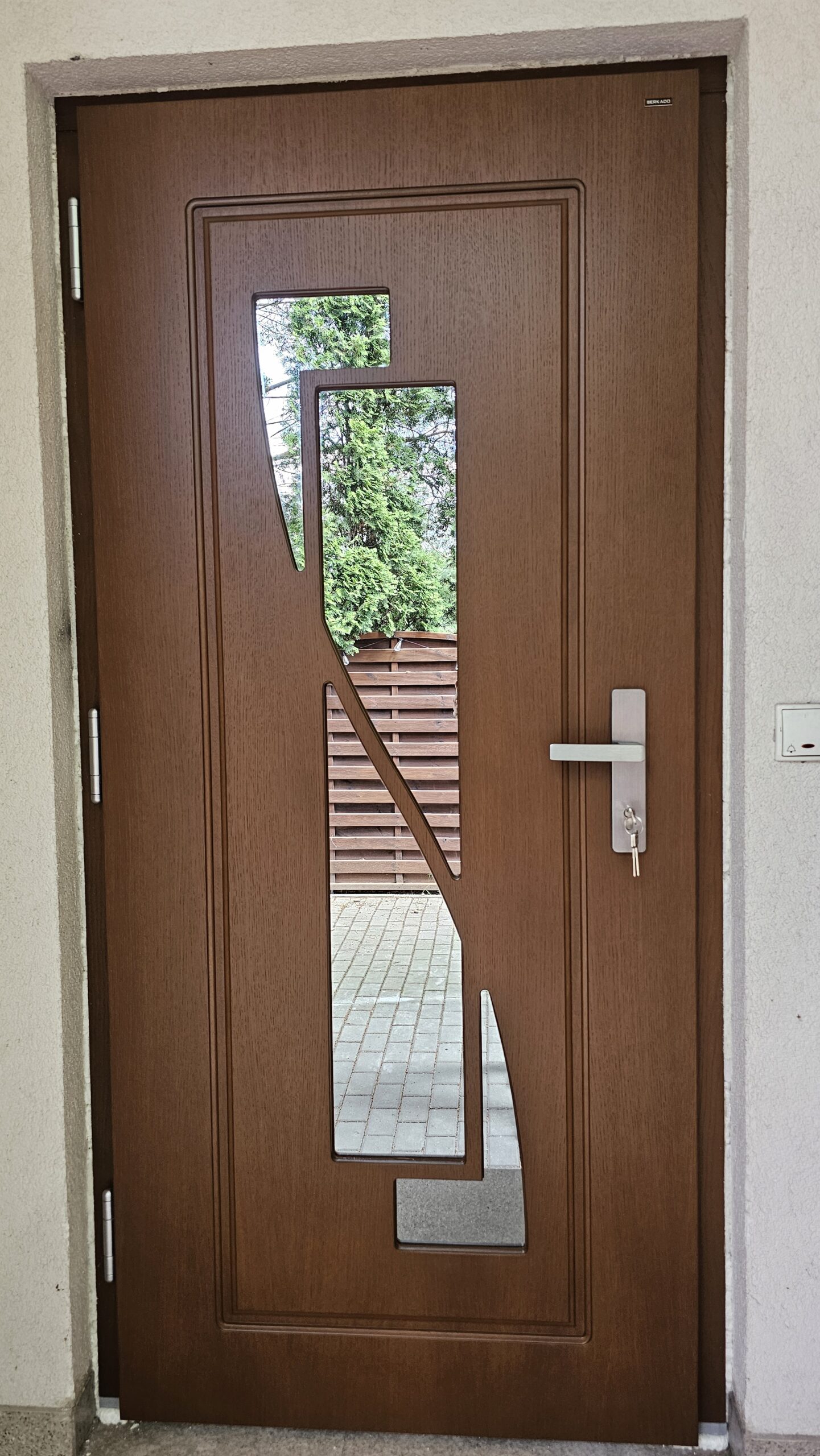 Brązowe drewniane drzwi zewnętrzne z przeszkleniem – realizacja DrzwiObornicka.pl