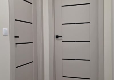 Nowoczesne drzwi wewnętrzne z czarnymi detalami – realizacja DrzwiObornicka.pl